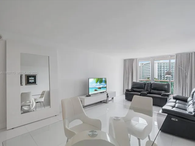 a living room with furniture a flat screen tv and a window