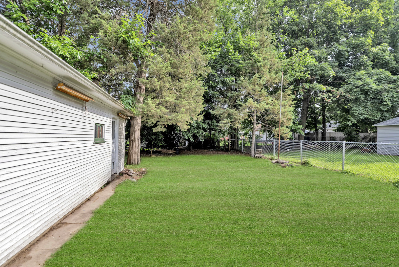 624 Lincoln Avenue Elgin, IL 60120 - Photo 24 of 24 a view of a white house in a big yard with large trees
