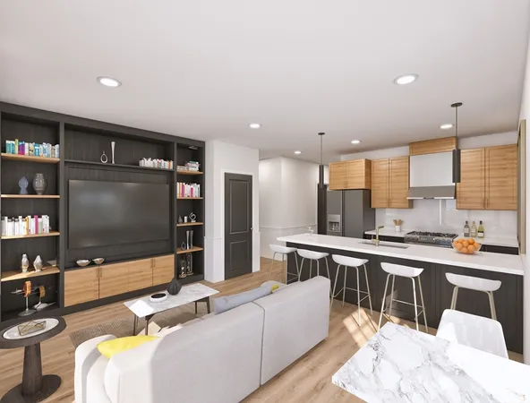 a living room with stainless steel appliances furniture and a flat screen tv
