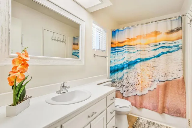 a bathroom with a sink mirror vanity and toilet