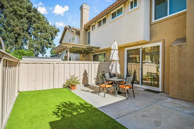 a view of a house with backyard and sitting area
