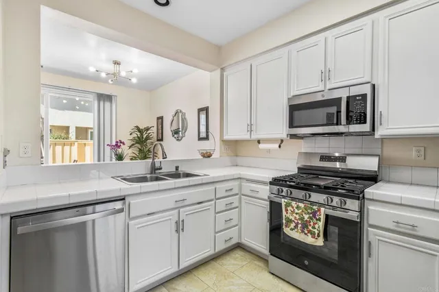 a kitchen with appliances a sink cabinets and a window