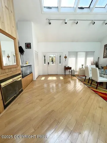 a kitchen with stainless steel appliances a refrigerator a stove a microwave a sink dishwasher and white cabinets with wooden floor