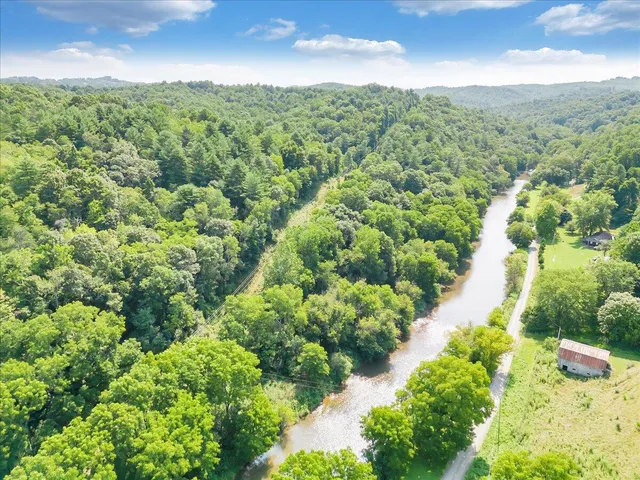 an aerial view of residential houses with outdoor space and trees