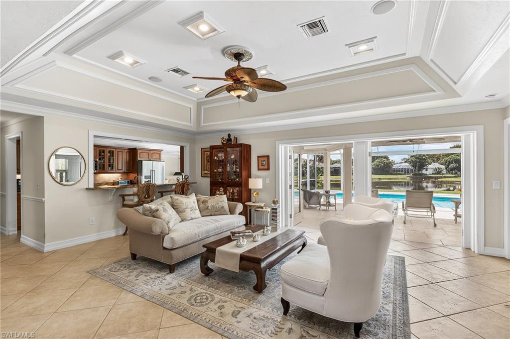 1904 Countess Court Naples, FL 34110 - Photo 1 of 33 a living room with furniture a chandelier fan and a large window