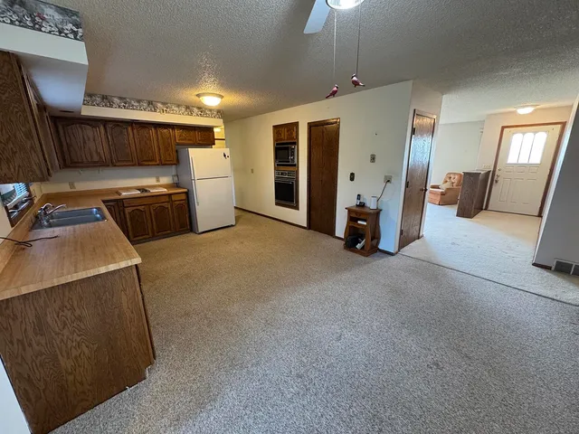 a view of a kitchen with refrigerator stove and wooden floor