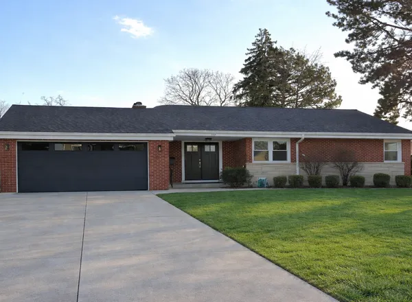 a front view of a house with a garden and yard