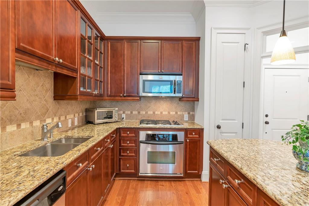 3635 East Paces Circle, Unit 1109 Atlanta, GA 30326 - Photo 9 of 22 a kitchen with stainless steel appliances granite countertop a stove a sink and a microwave