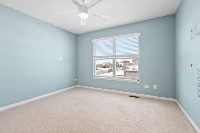 an empty room with a window and a fan