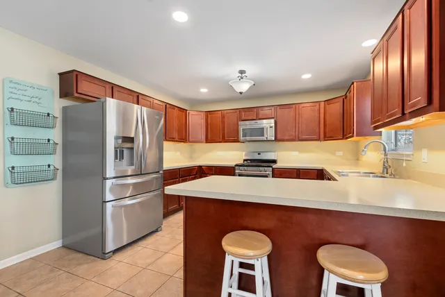 a kitchen with stainless steel appliances granite countertop a sink refrigerator stove and microwave