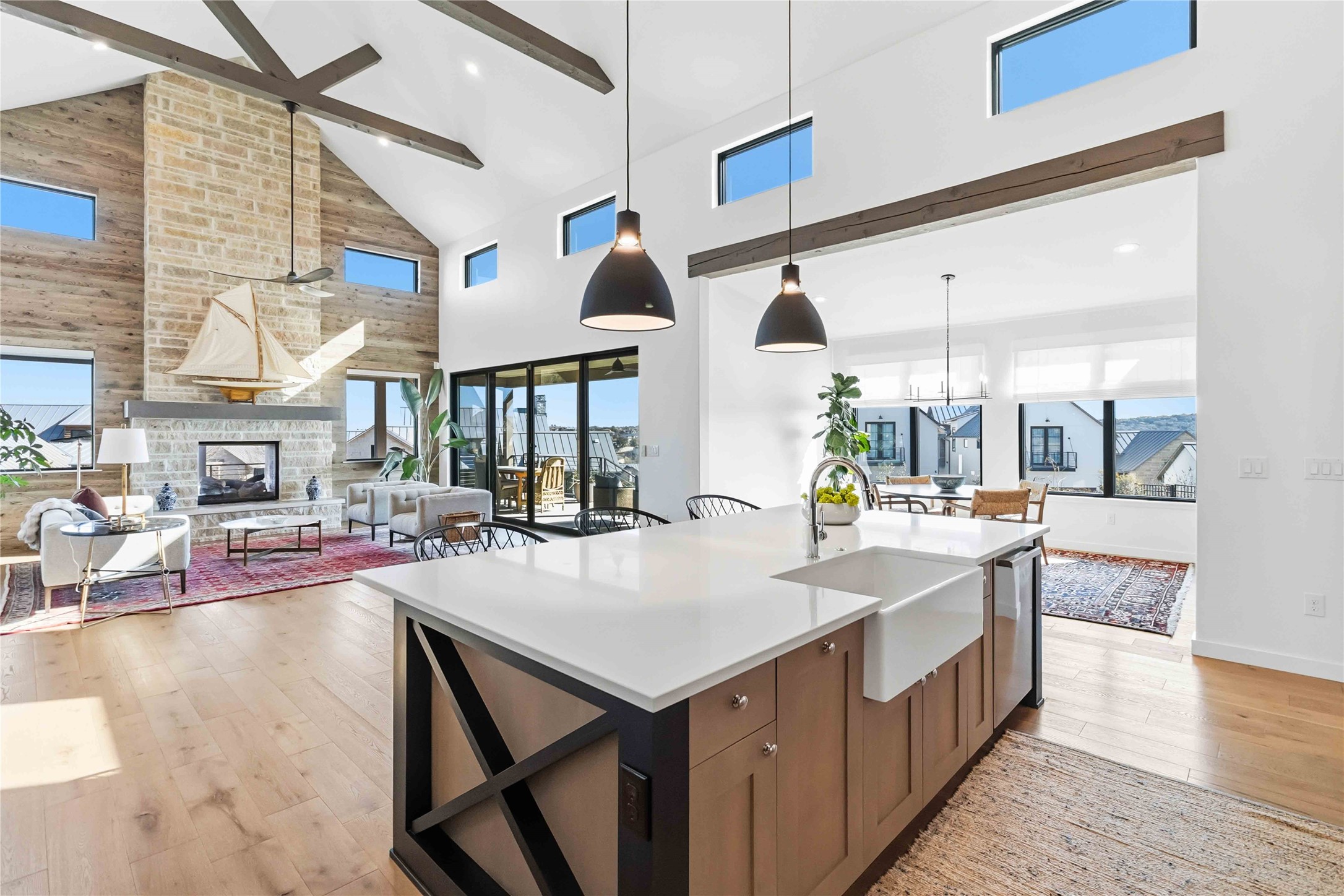 410 Kayak Way Austin, TX 78738 - Photo 40 of 40 Kitchen featuring a fireplace, decorative light fixtures, light wood-style flooring, open floor plan, and wood finish cabinets