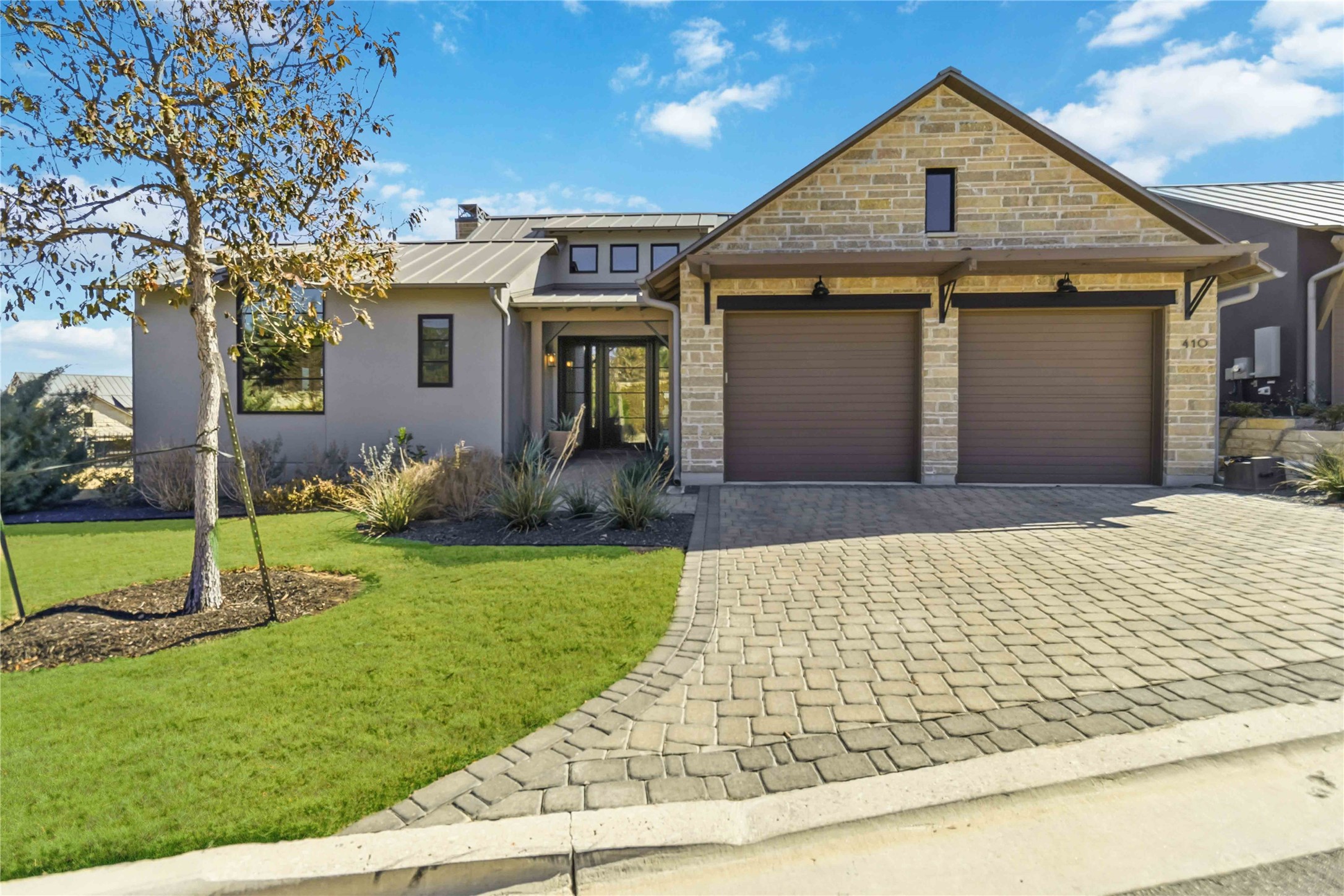 410 Kayak Way Austin, TX 78738 - Photo 2 of 39 View of front of house with decorative driveway, a front lawn, stone siding, stucco siding, and an attached garage