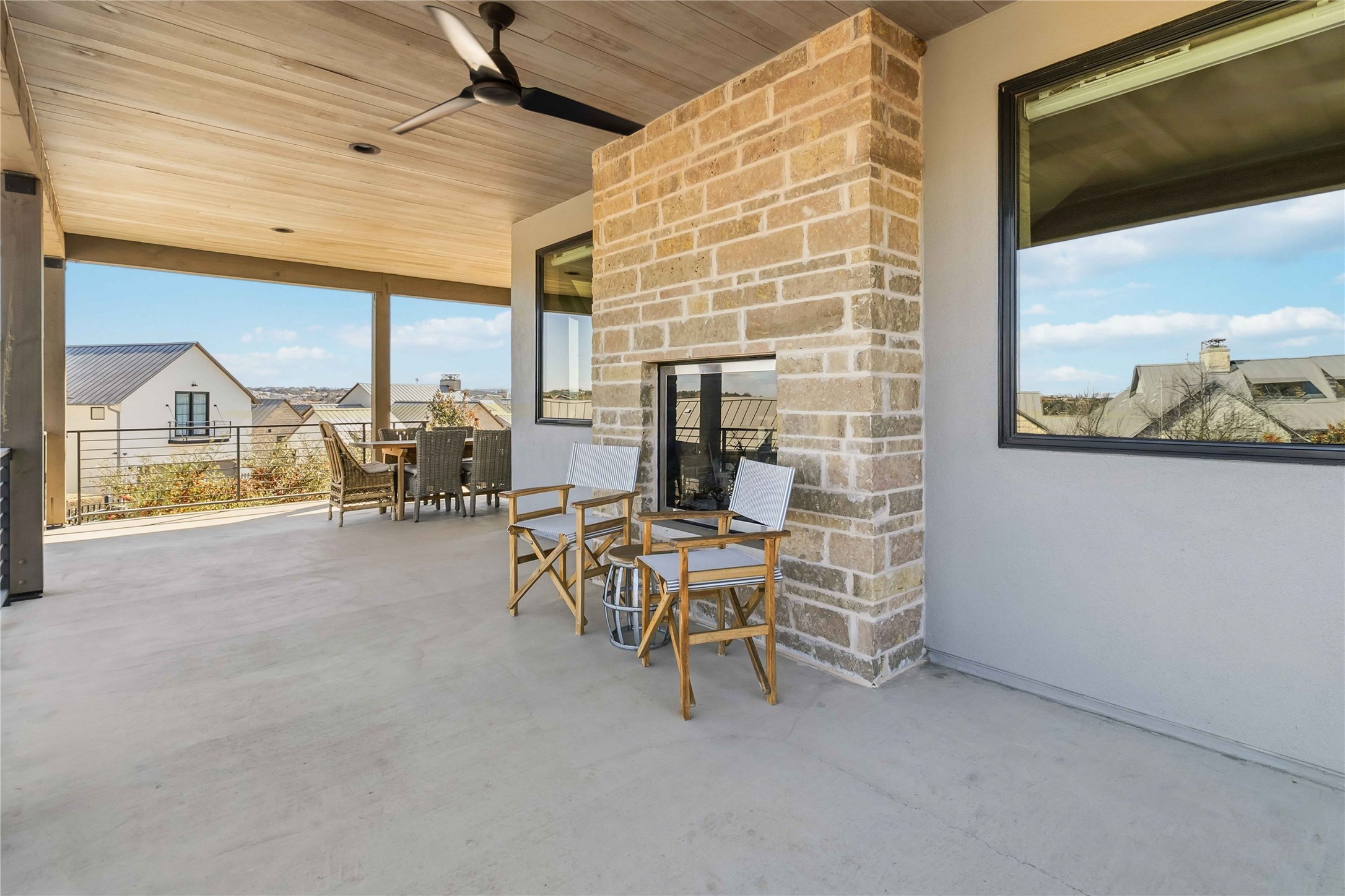 410 Kayak Way Austin, TX 78738 - Photo 31 of 39 View of patio / terrace with ceiling fan, outdoor dining space, an outdoor stone fireplace, and a residential view