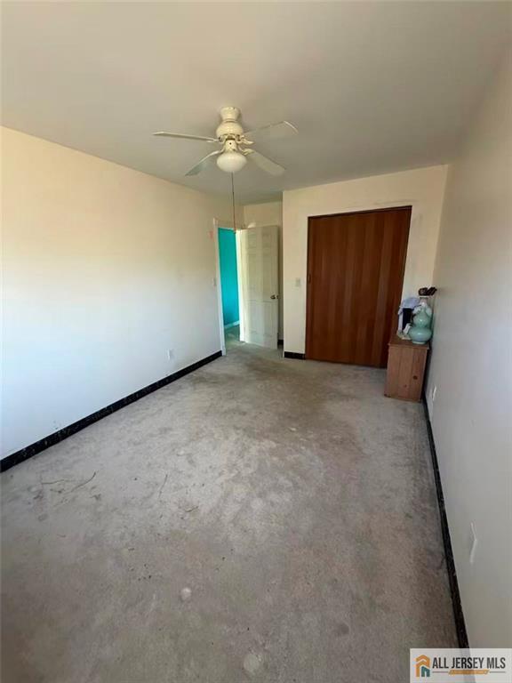 57 North Disbrow Hill Road Monroe Township, NJ 08831 - Photo 18 of 24 an empty room with a chandelier fan and windows