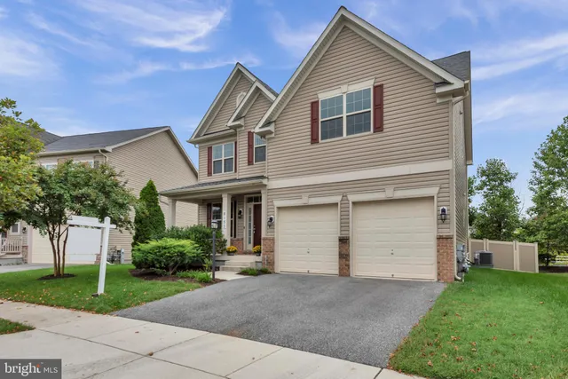 a view of a white house with a small yard and a large tree