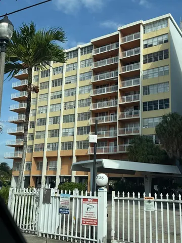 a front view of a building with a garden