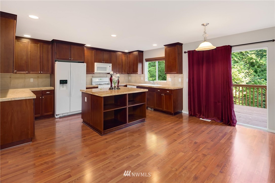 2522 Stafford Way Bothell, WA 98012 - Photo 7 of 23 a kitchen with stainless steel appliances granite countertop a stove refrigerator and wooden floor