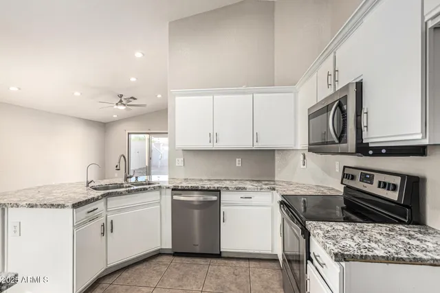 a kitchen with granite countertop a sink stainless steel appliances and cabinets