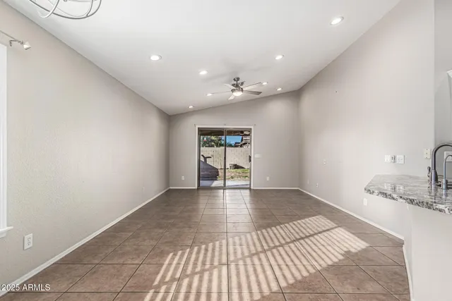 a view of an empty room and kitchen view