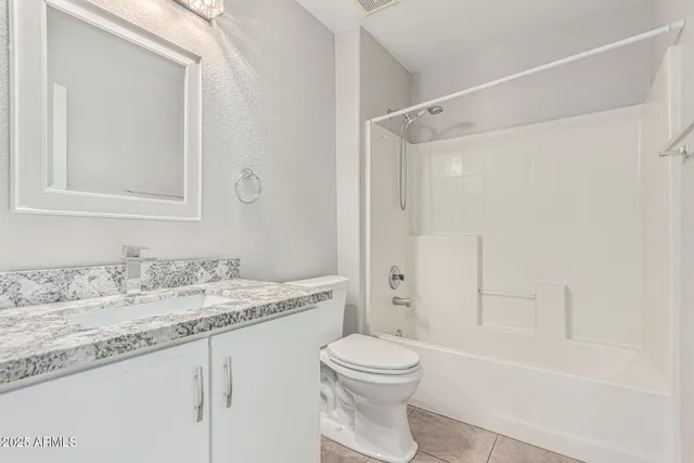 an empty room with wooden floor chandelier fan and windows