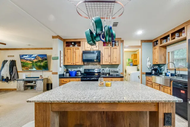 a kitchen with sink and view of living room