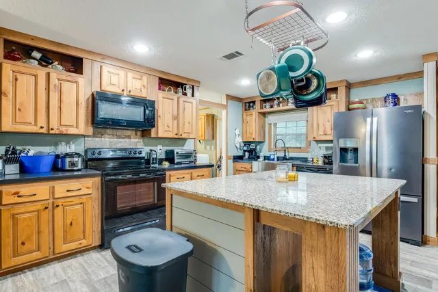 a kitchen with stainless steel appliances granite countertop a sink a stove and refrigerator