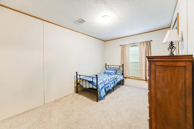 a room with a bed and a refrigerator