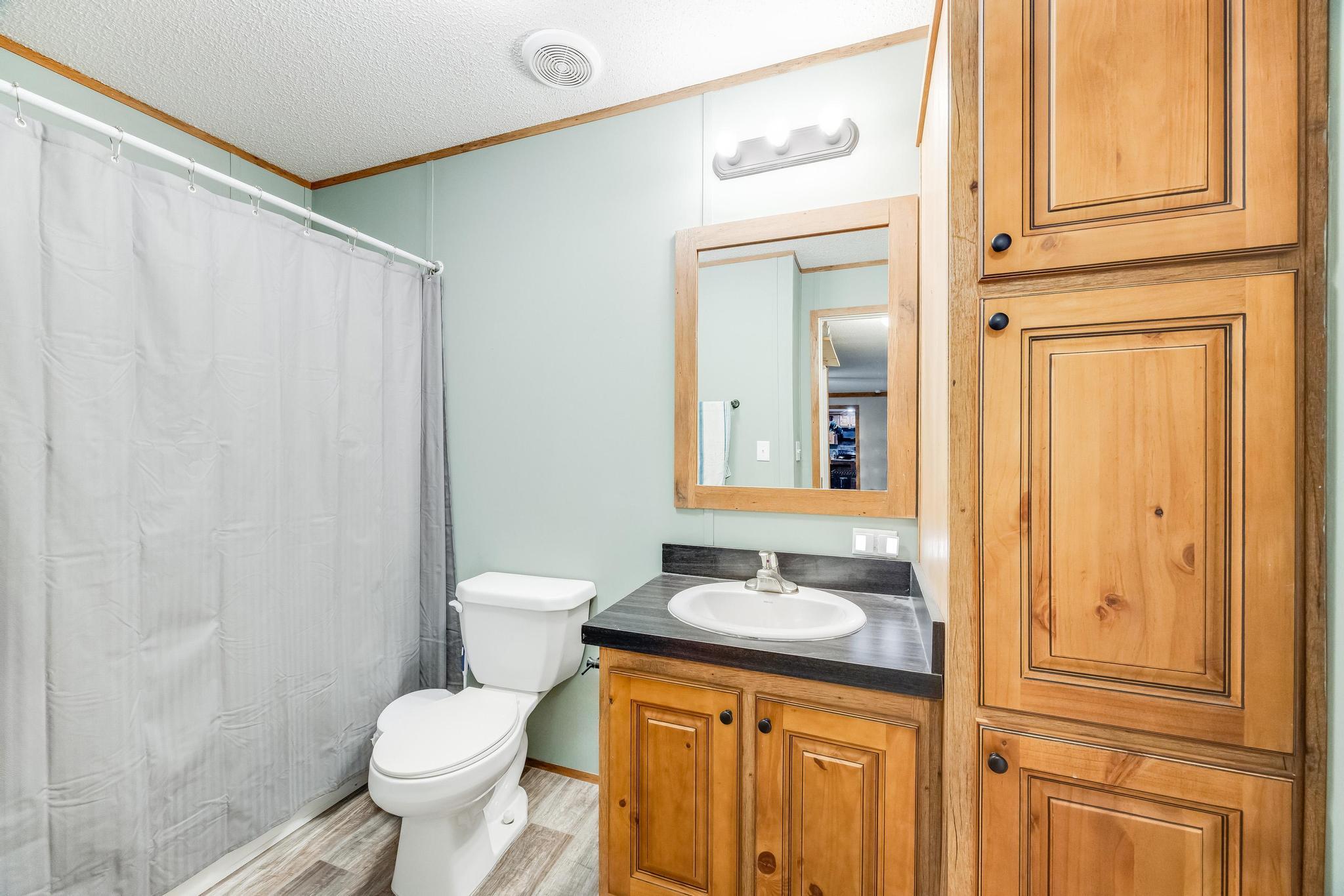 6224 Old River Road Baker, FL 32531 - Photo 24 of 35 a bathroom with a granite countertop sink toilet and shower