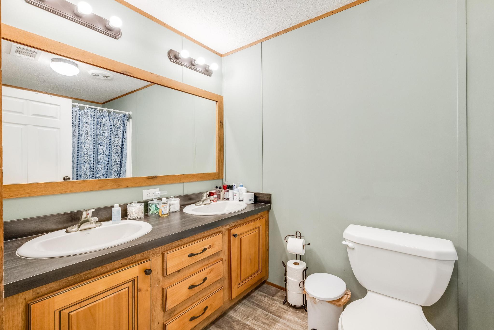6224 Old River Road Baker, FL 32531 - Photo 25 of 35 a bathroom with a granite countertop toilet sink and mirror