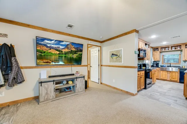 a view of living room with stainless steel appliances furniture and flat screen tv