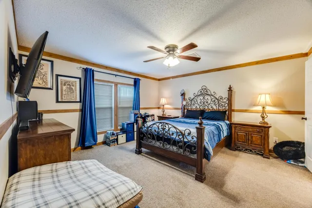 a bedroom with a large bed and a chandelier