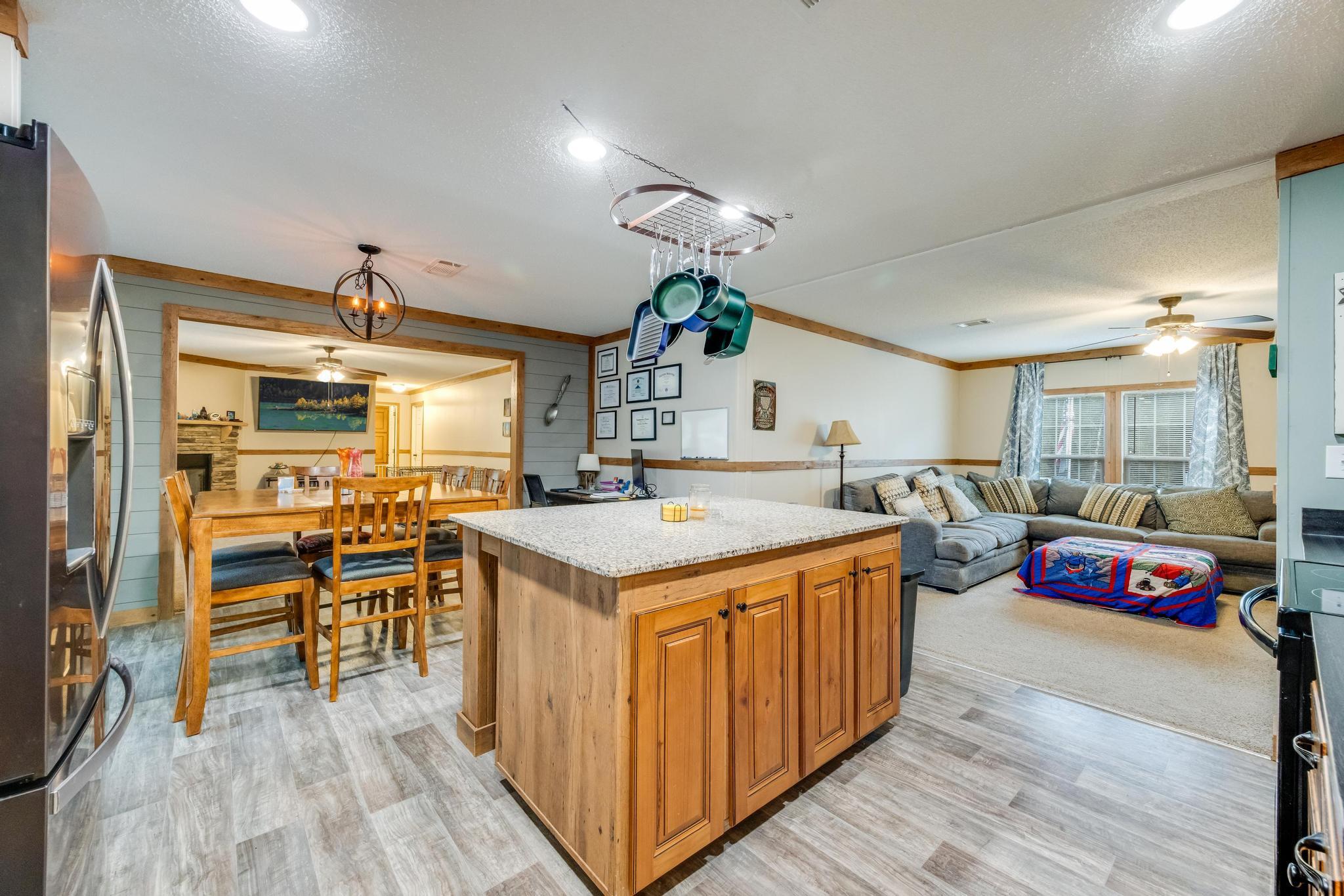 6224 Old River Road Baker, FL 32531 - Photo 10 of 35 a kitchen with kitchen island granite countertop wooden floors and a view of living room