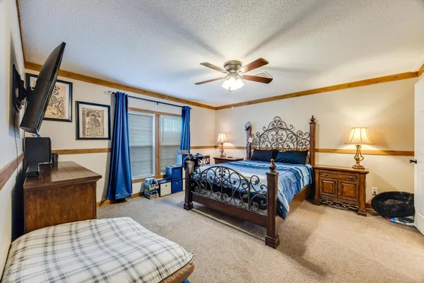 a bedroom with a large bed and a chandelier