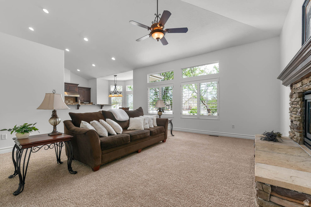 439 East 13540 South Draper, UT 84020 - Photo 5 of 46 Vaulted ceiling living room featuring a stone-clad fireplace with a stone hearth, recessed lighting, and a ceiling fan