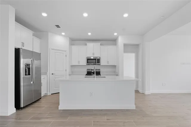 a view of kitchen with stainless steel appliances refrigerator oven and stove