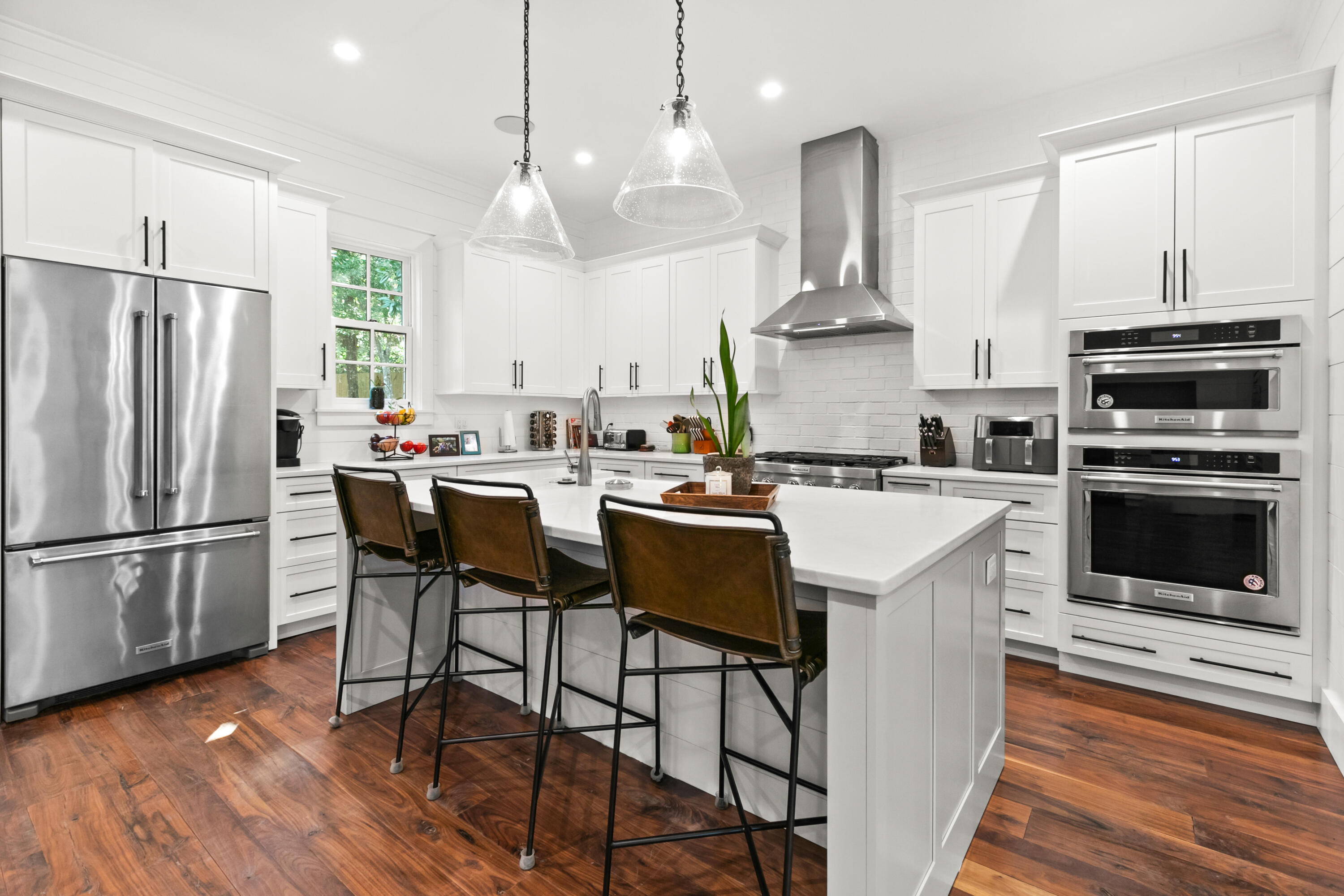 380 Ricker Avenue Santa Rosa Beach, FL 32459 - Photo 6 of 55 a kitchen with stainless steel appliances a stove a sink island and a refrigerator with wooden floor