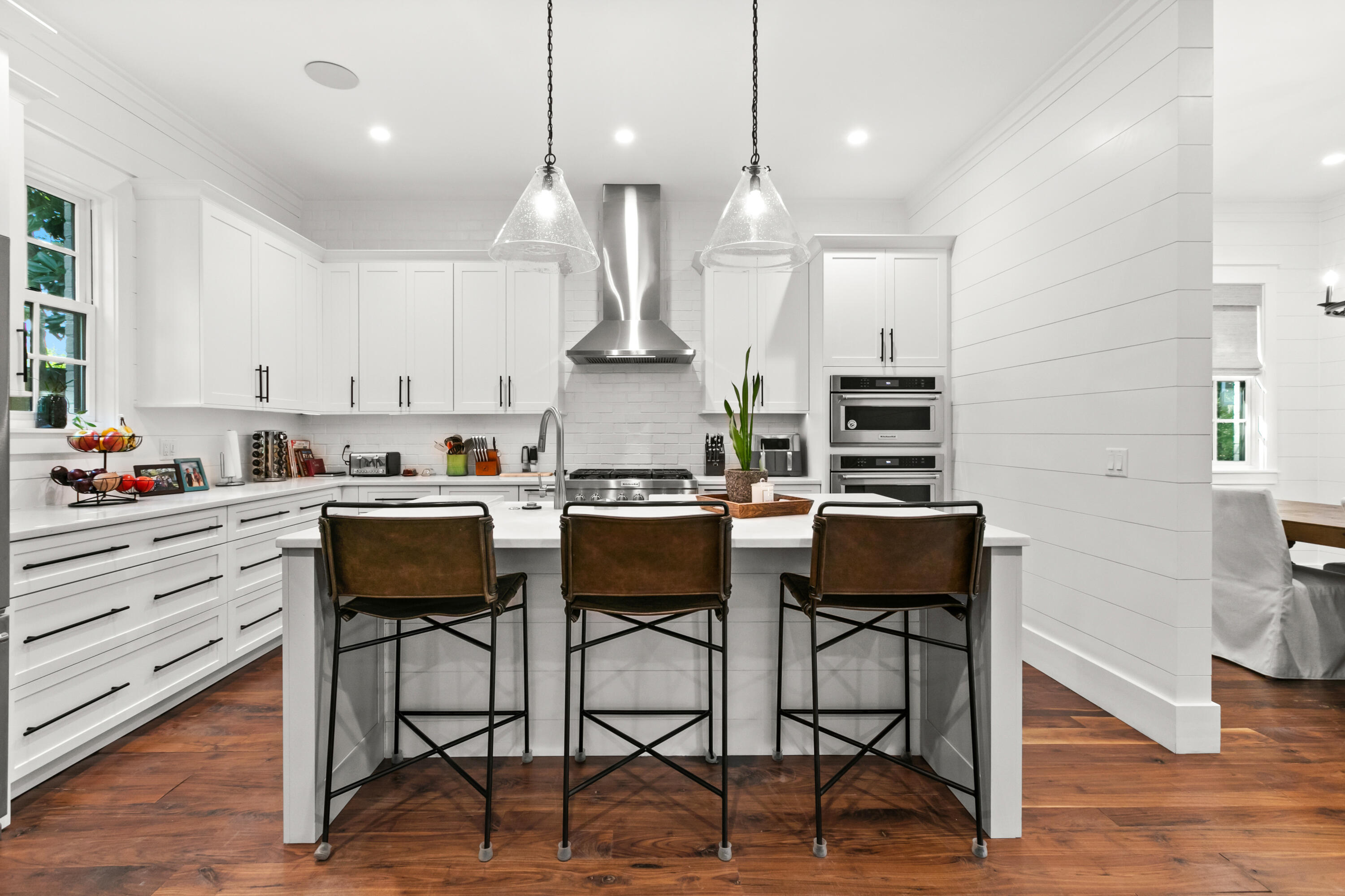 380 Ricker Avenue Santa Rosa Beach, FL 32459 - Photo 7 of 55 a kitchen with stainless steel appliances kitchen island granite countertop a stove top oven a sink a dining table and chairs with wooden floor