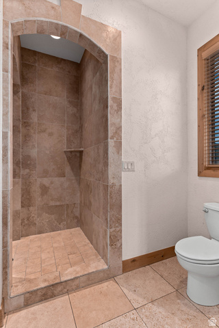 2464 East Granite Way St. George, UT 84790 - Photo 80 of 106 Full bathroom featuring a shower stall, a textured wall, and tile patterned flooring