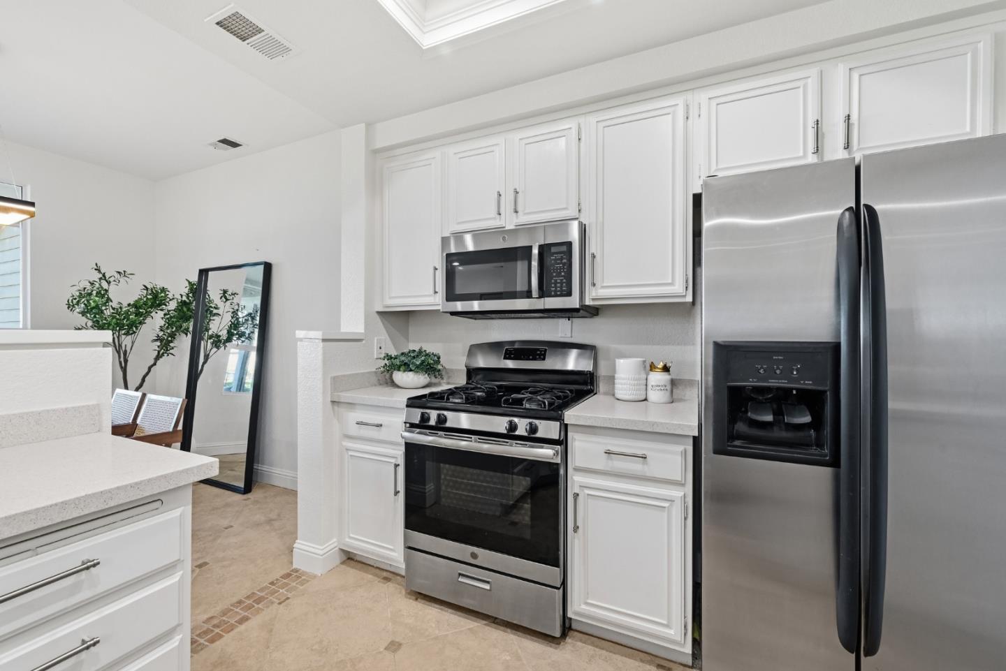 34590 Falls Terrace Fremont, CA 94555 - Photo 13 of 38 a kitchen with white cabinets and stainless steel appliances