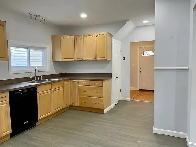 a kitchen with granite countertop a sink and cabinets