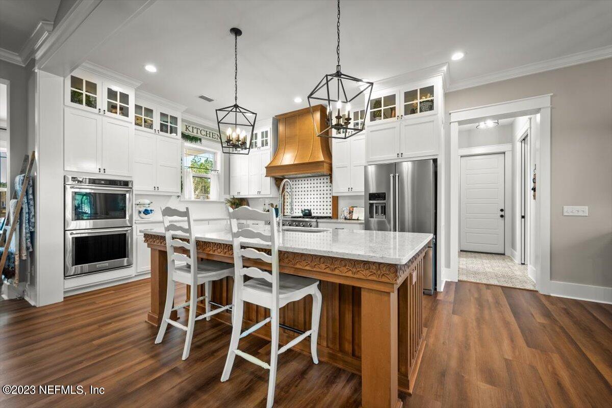 3200 Jane Lane Hilliard, FL 32046 - Photo 14 of 72 a kitchen with stainless steel appliances granite countertop a table chairs refrigerator and sink