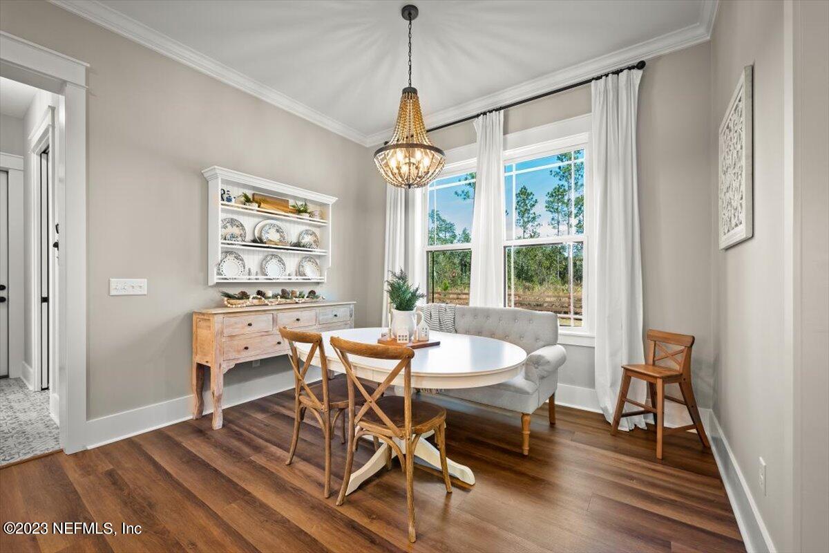 3200 Jane Lane Hilliard, FL 32046 - Photo 19 of 72 a dining room with wooden floor a chandelier a wooden table and chairs