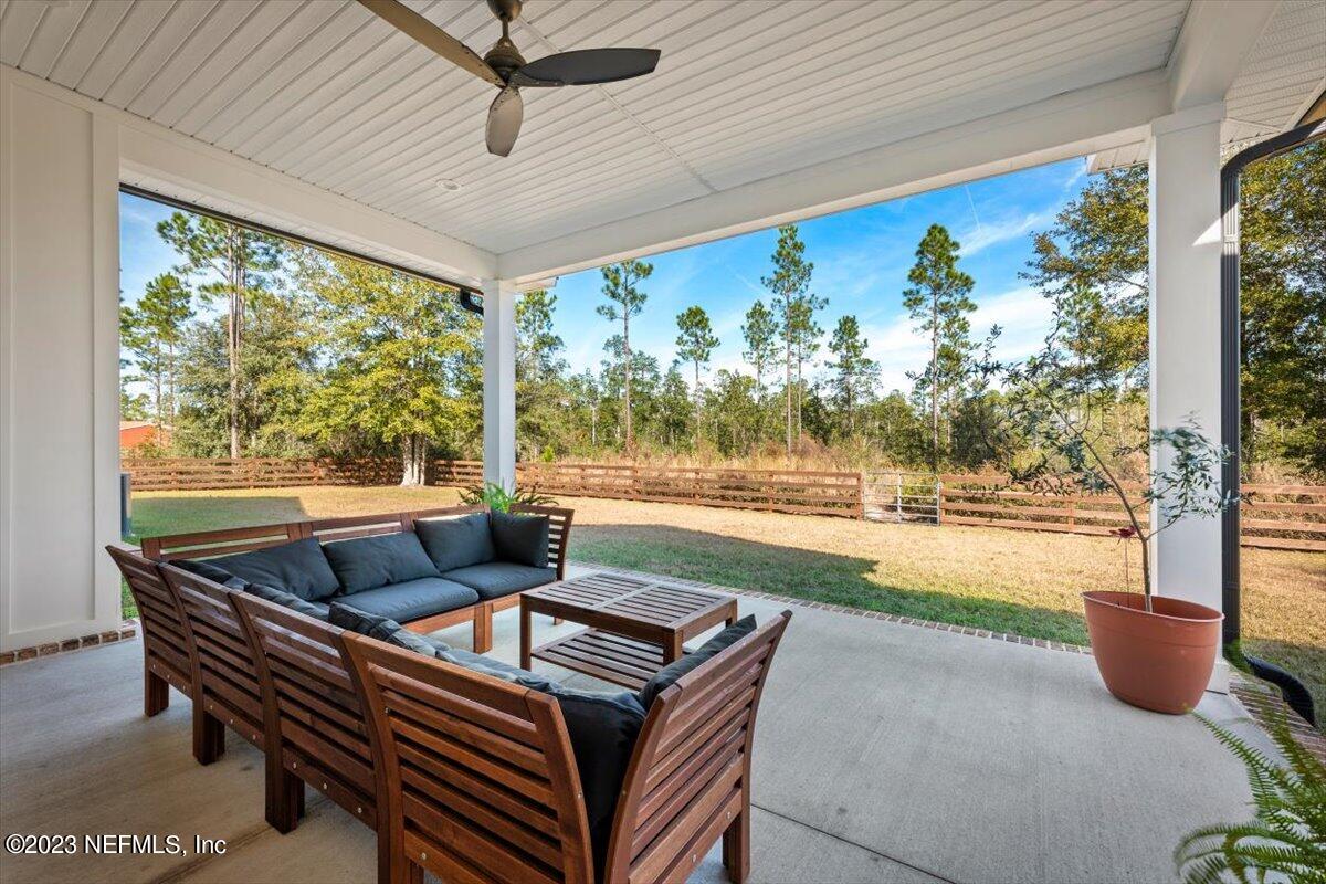 3200 Jane Lane Hilliard, FL 32046 - Photo 44 of 72 a living room with patio furniture and a floor to ceiling window