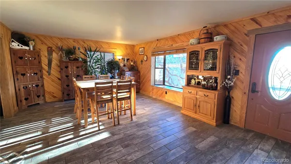 a dining room with furniture window and wooden floor