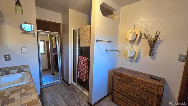 a view of a hallway with entryway and wooden floor