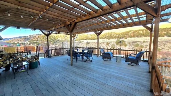 a outdoor space with chairs a couch and wooden floor