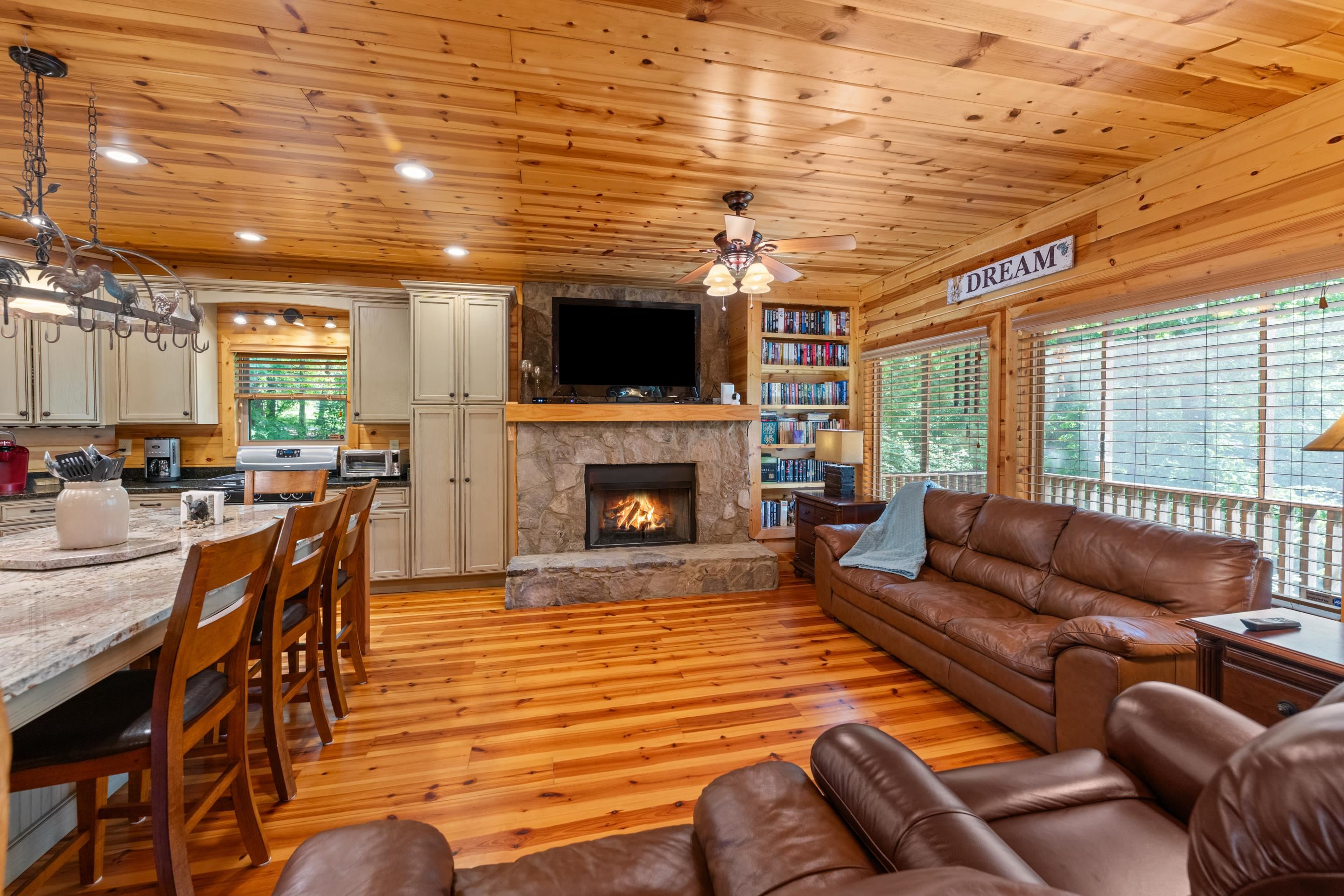 950 Cherry Road Eads, TN 38028 - Photo 8 of 30 Open-concept living space featuring wood-finish flooring, a stone fireplace, and extensive wood paneling