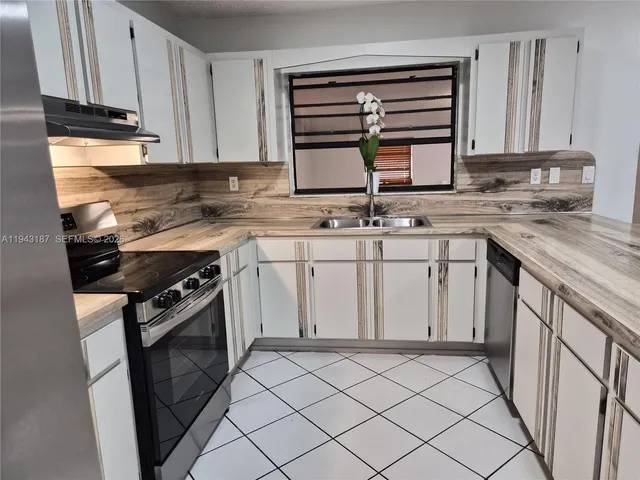 a kitchen with a sink stove and cabinets