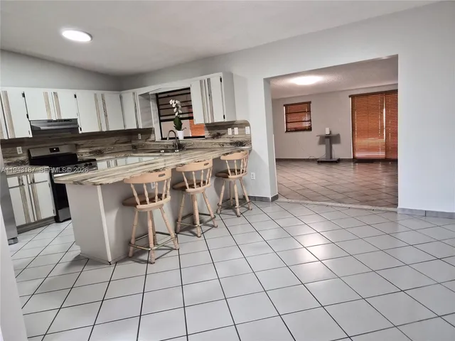 a kitchen with stainless steel appliances a stove a sink a counter top space and cabinets