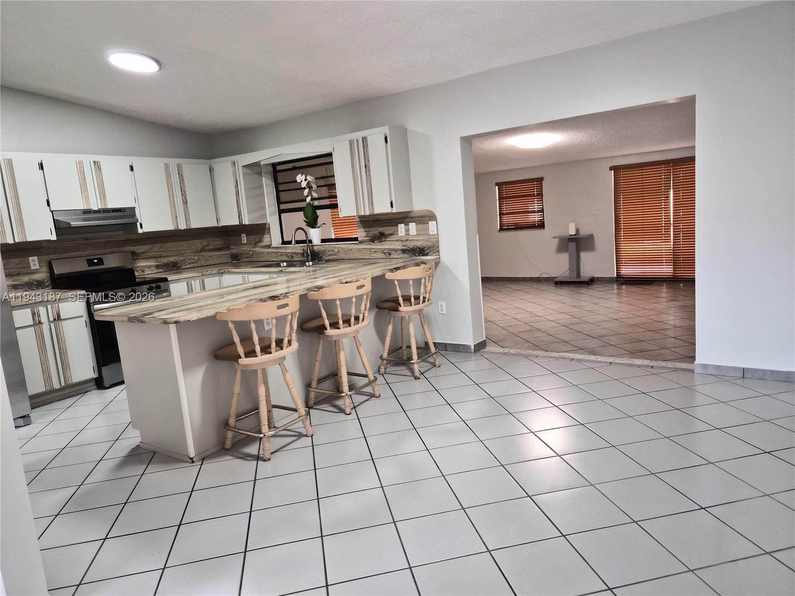 1453 Southwest 137th Place Miami, FL 33184 - Photo 15 of 22 a kitchen with stainless steel appliances a stove a sink a counter top space and cabinets